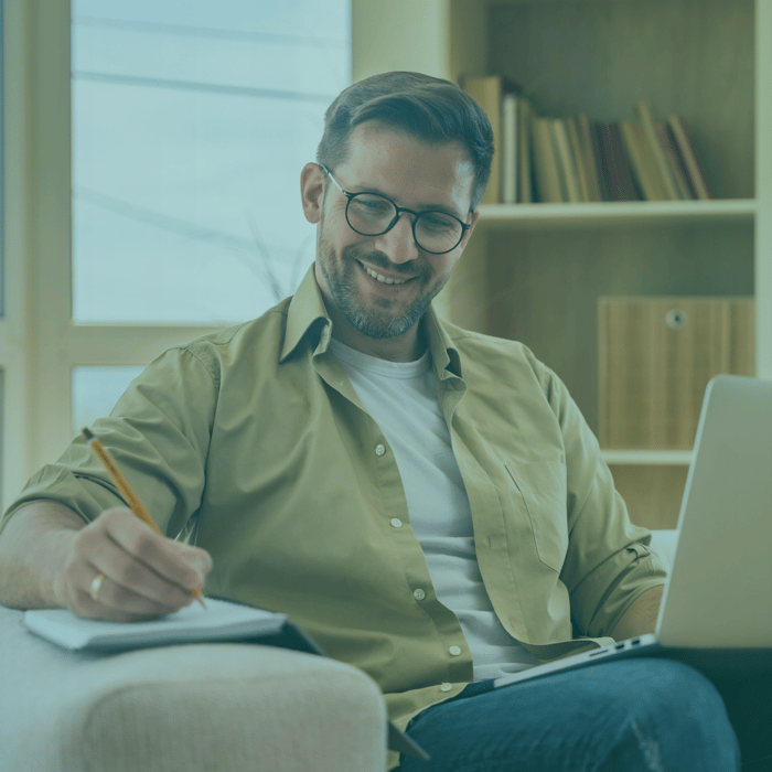 Man smiling while taking notes